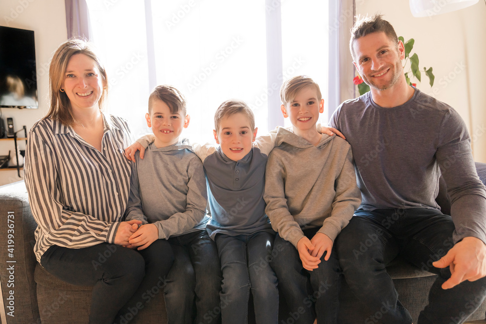 Family of five Relaxing Together On Sofa