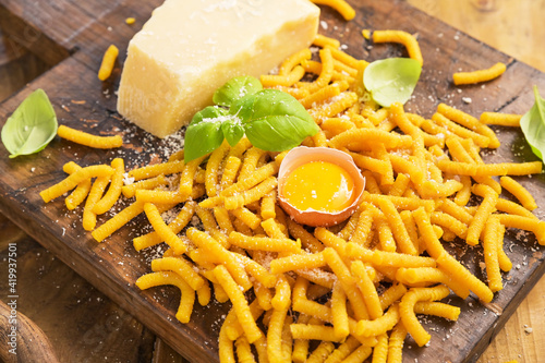 Traditional Pasta cooked in chicken broth , fresh pasta. Passatelli in brodo. A pasta formed of eggs, grated Parmesan cheese. Typical for and Emilia Romagna. Parmesan is poured. Above