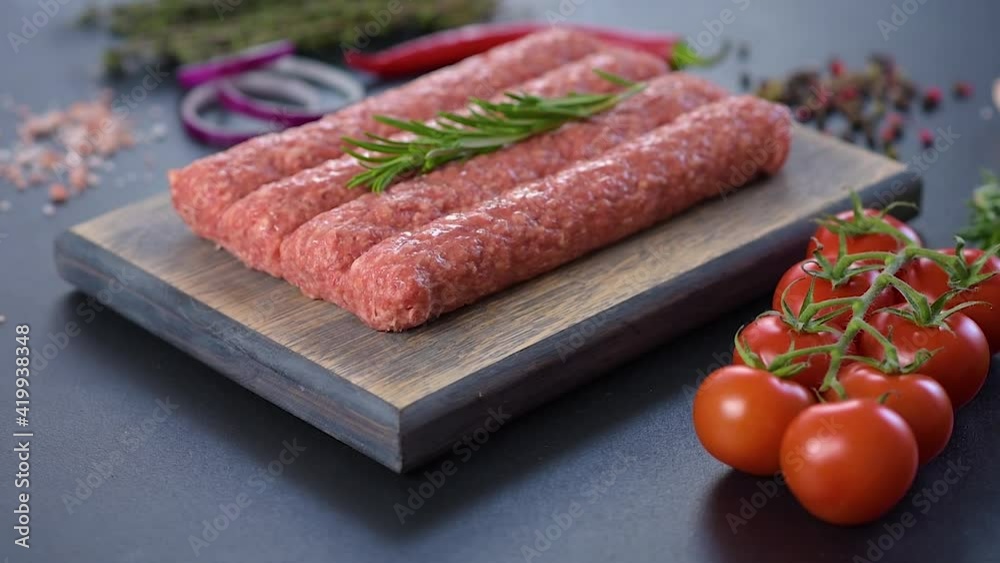 Fresh raw mince for grilled kebab with spices and herbs on a dark concrete background Fresh raw mince for grilled kebab with spices and herbs on a dark concrete background