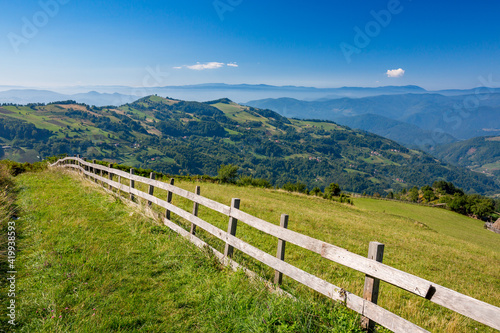 Long wooden fence along a mountain road with a scenery hills landscape  Western Serbia. Bio stock-breeding and farming.
