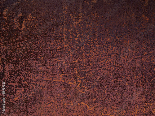 Uneven texture of cracked, weathered, faded, rotted flakes of rust on a sheet of iron. The background of a metal garage wall, the gate of an old abandoned factory. Shades of red, orange, brown.