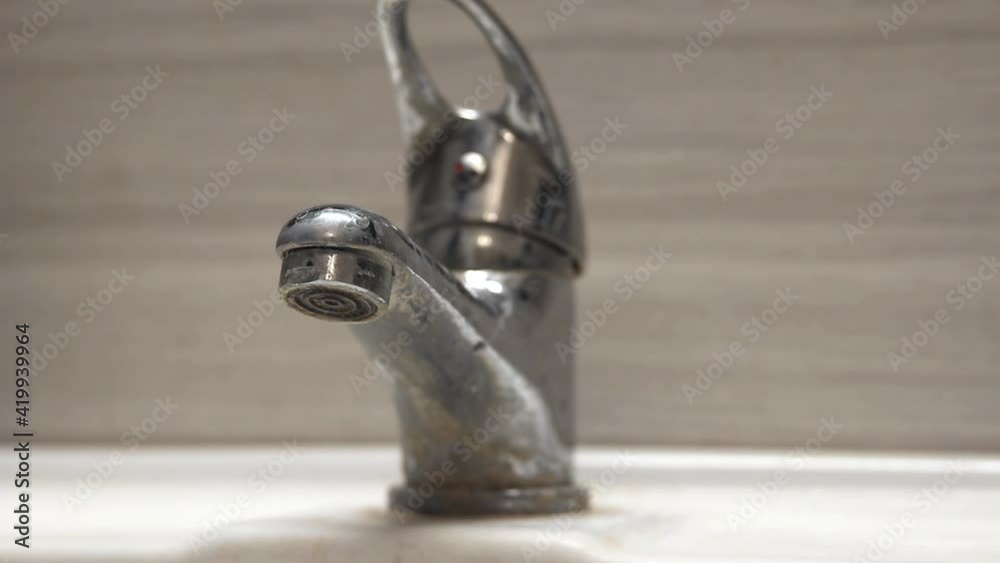 Problems with water supply. Old bathroom sink faucet contaminated with calcium and grime. Problems with water supply. Old bathroom sink faucet contaminated with calcium and grime.