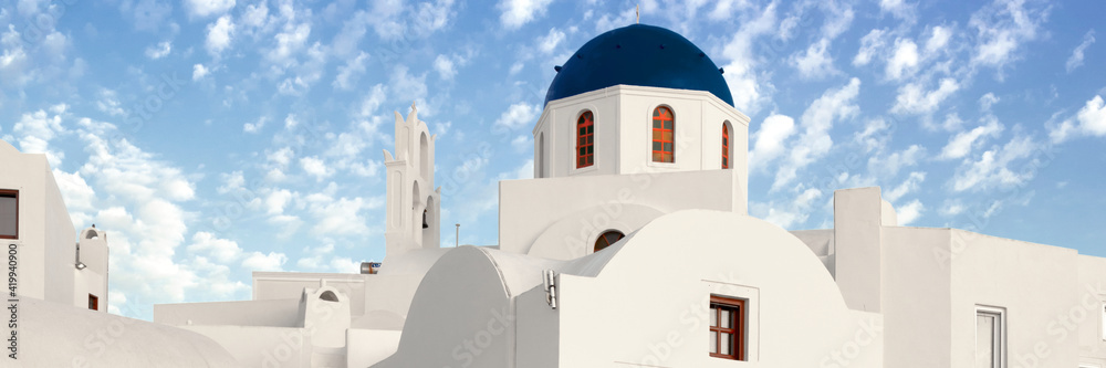 Beautiful white houses and local church with blue cupola in Oia