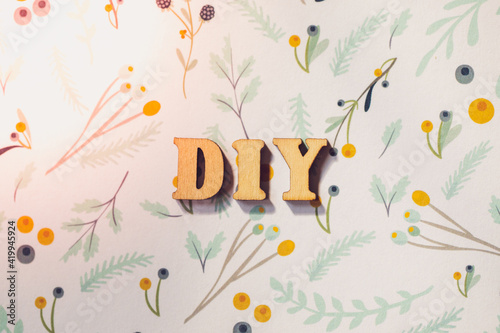 wooden letters spelling out  DIY  on craft paper