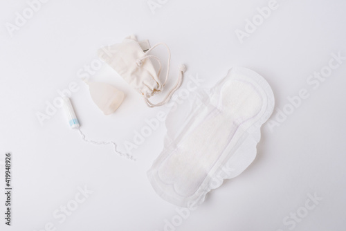 Photo of tampon, menstrual cup.Concept of critical days, menstruation, over white background