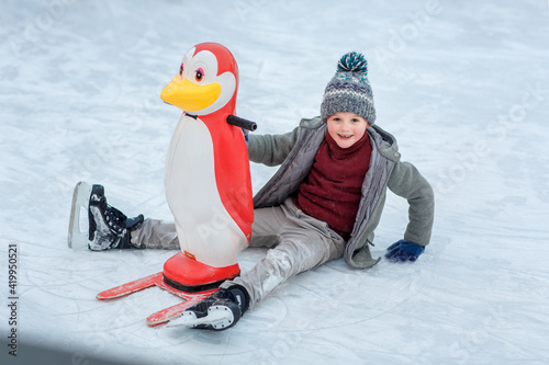a boy in a coat learns to skate on ice skates