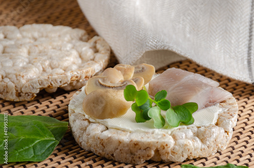 Diet popped wheat cakes with herring, champignons and greens.