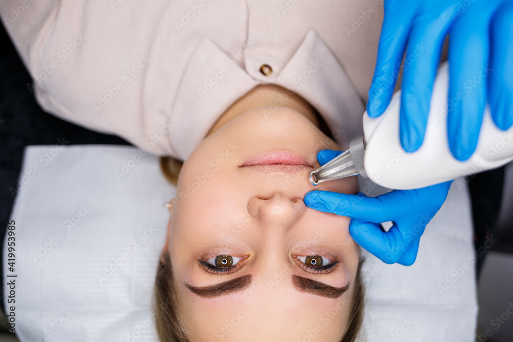 Laser removal of permanent makeup on the face. Close-up of a young woman getting tattoo correction. Correction of natural imperfections on the face. Laser removal of permanent makeup on the face. Close-up of a young woman getting tattoo correction. Correction of natural imperfections on the face.