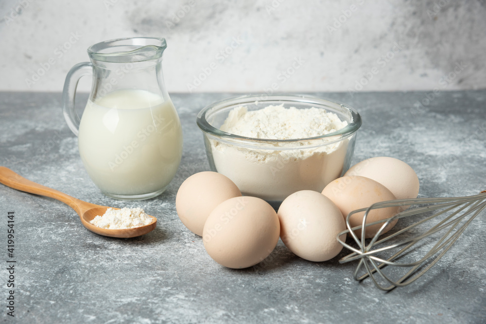 Bowl of flour, eggs and milk on marble background Bowl of flour, eggs and milk on marble background