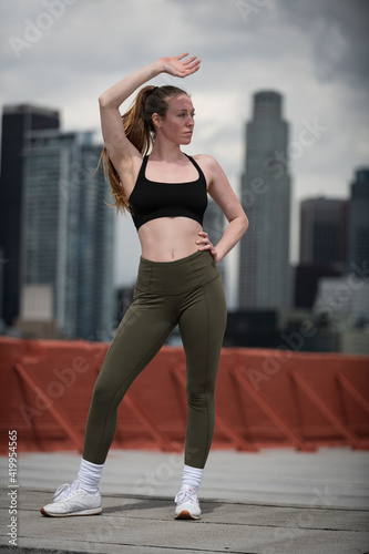 Fototapeta Naklejka Na Ścianę i Meble -  Young Athlete Warms Up on Los Angeles Rooftop