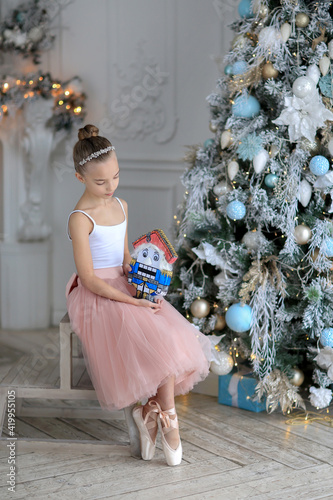 A small ballerina near the Christmas tree. The Nutcracker . New Year's gifts