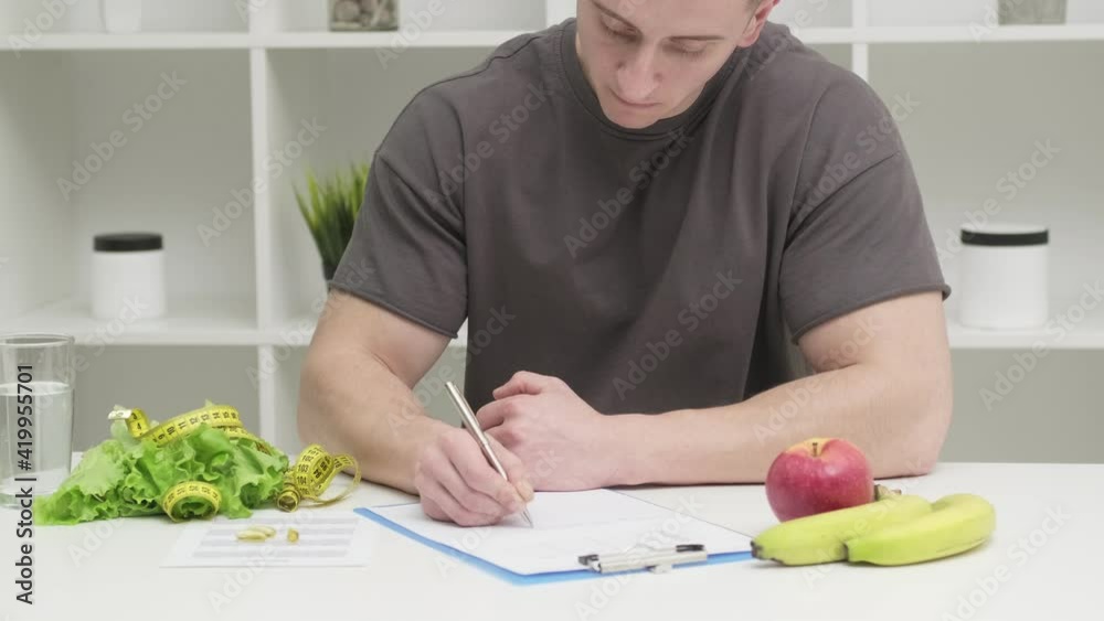 A man of athletic build makes a diet plan A man of athletic build makes a diet plan