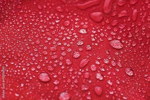 Red waterproof cloth covered with water drops