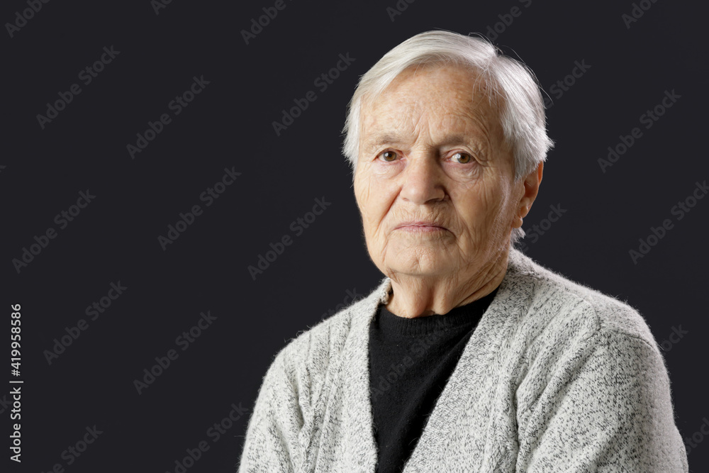 Studio portrait of 80 years old woman on black background