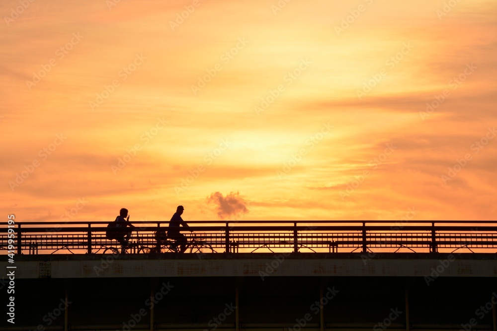 bicycle crossing the bridge. “Golden hour” dim light sky. blurred focus silhouette image. Japan・tokyo. bicycle crossing the bridge. “Golden hour” dim light sky. blurred focus silhouette image. Japan・tokyo.