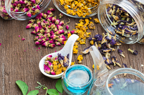 Flower herbal Tea with Butterfly pea, Rose, Chrysanthemum, flower tea in a glass teapot on wooden background