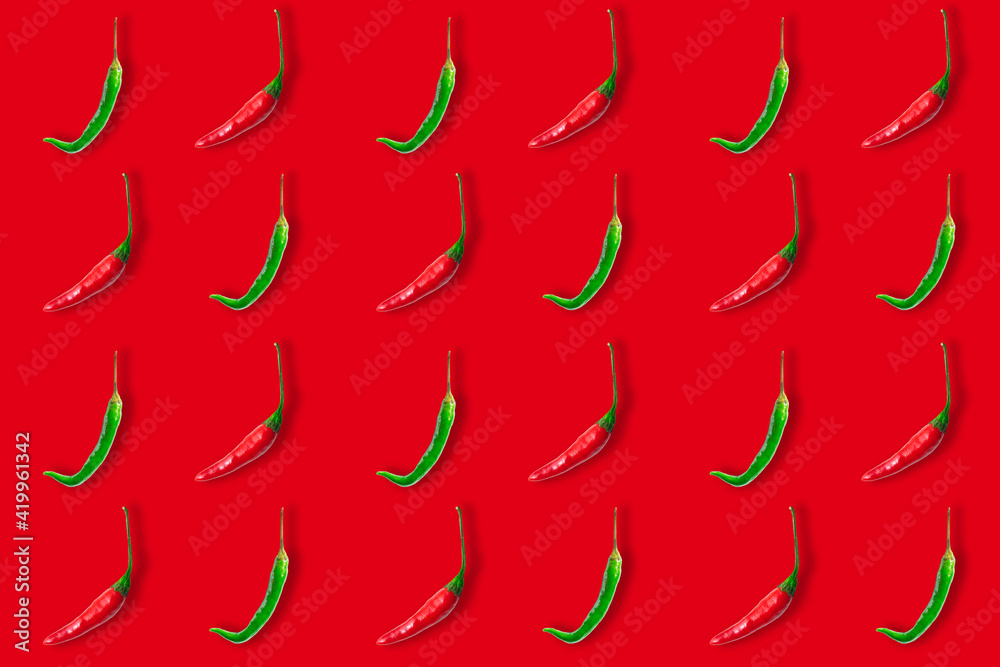 Seamless pattern of red and green hot chili peppers isolated on red background. Top view. Flat lay Seamless pattern of red and green hot chili peppers isolated on red background. Top view. Flat lay