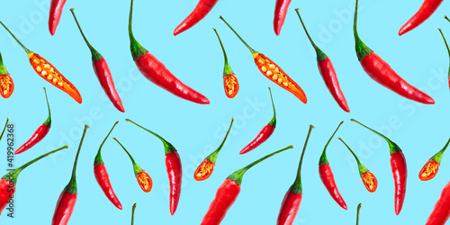 Seamless pattern of red hot chilli peppers isolated on blue background. Top view