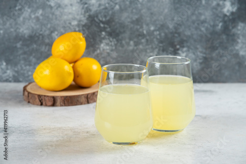 Two glass cups of lemonade with lemons