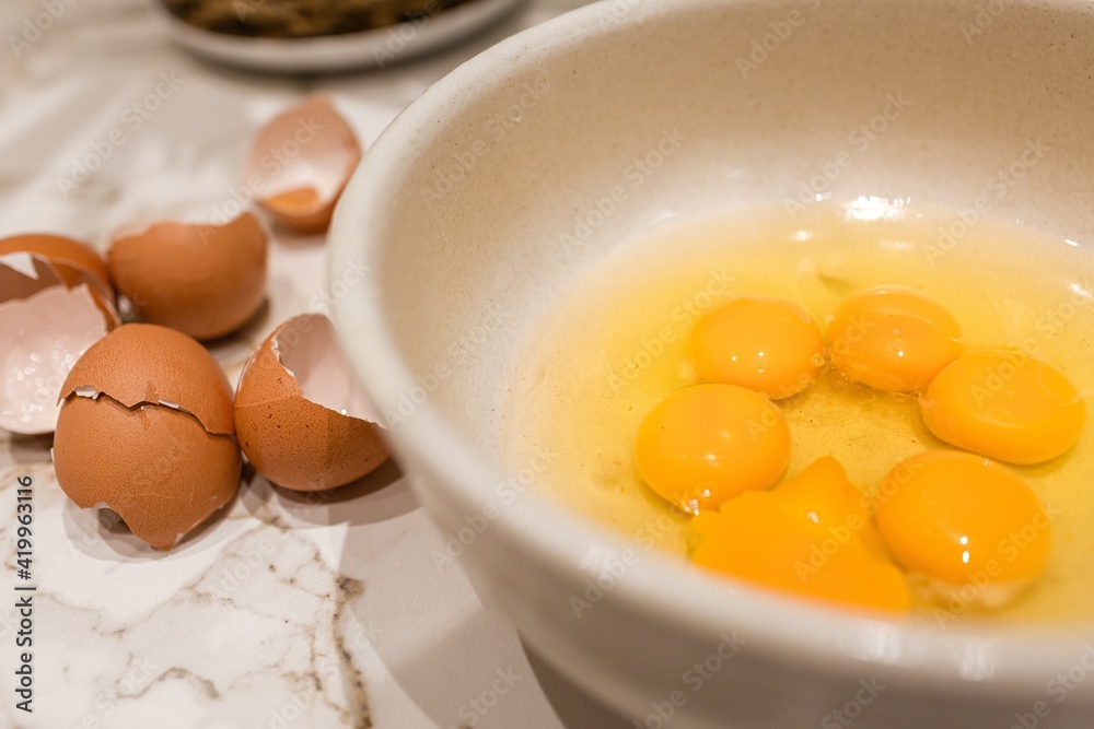 Bowl with 6 egg yolks and shells on the side Bowl with 6 egg yolks and shells on the side