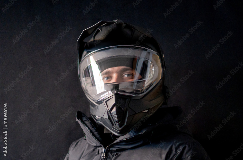 Motorcyclist wearing a black dual-purpose motorcycle helmet with a black jacket.