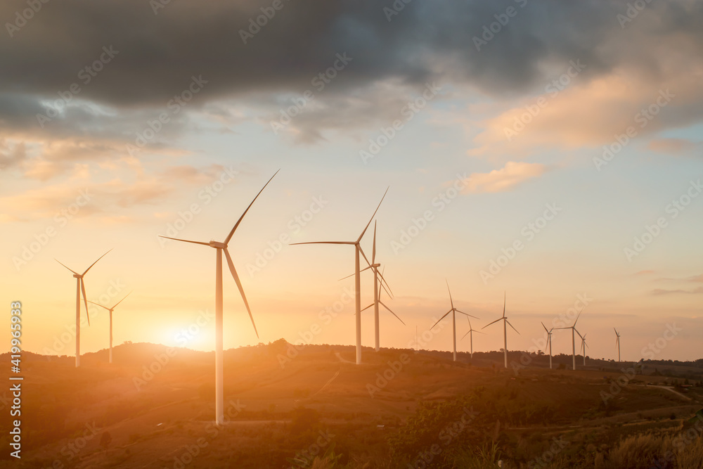 Silhouette of wind turbines. Beautiful view of wind generators in the mountain hill at sunset.