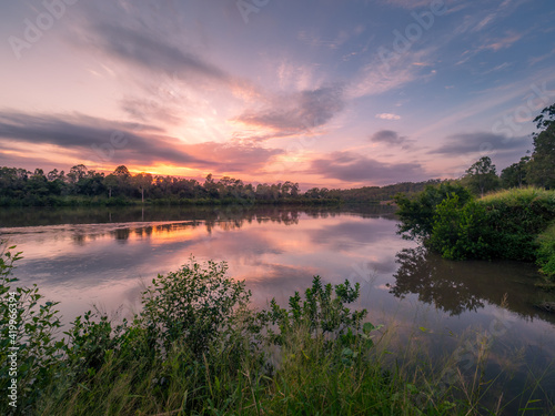 Fototapeta Naklejka Na Ścianę i Meble -  Riverside Sunrise with Cloud Reflections