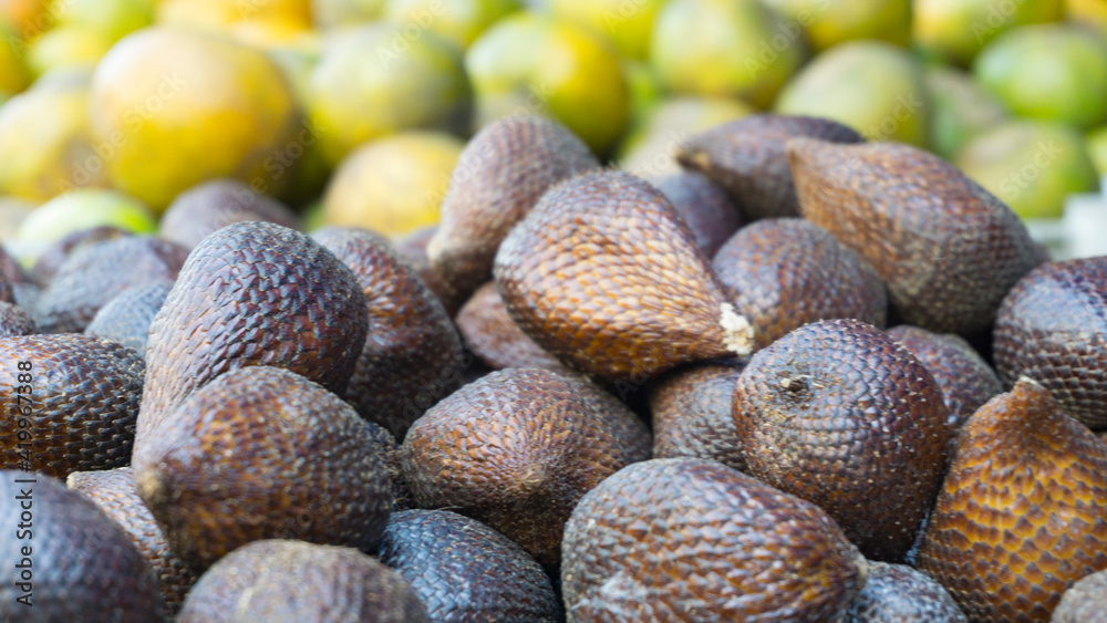 snake fruit in the market on a blurry orange background