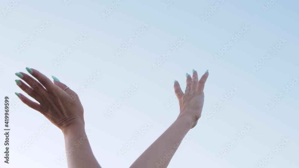 Isolation woman's hands dancing over blue sky background, slow motion Isolation woman's hands dancing over blue sky background, slow motion