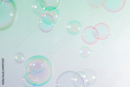 Beautiful blur transparent green and pink soap bubbles floating background. 