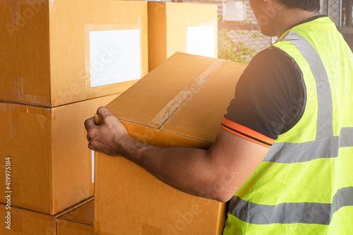 Warehouse worker stcking cardboard boxes at storage warehouse. Shipment boxes. photo