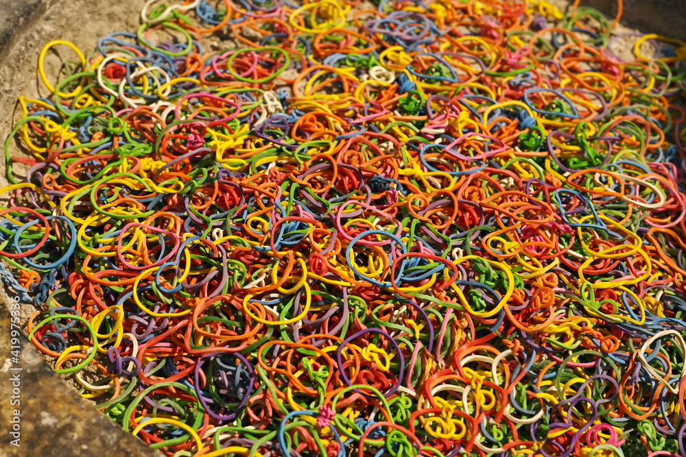 Colored rubber bands were removed from the incense and candles of the monks and left in the temple's cement censer for reuse. Natural resource recycling concept
Colored rubber bands were removed from the incense and candles of the monks and left in the temple's cement censer for reuse. Natural resource recycling concept