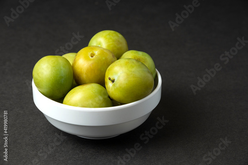 Green plums in a white ceramic saucer © azerbaijan-stockers