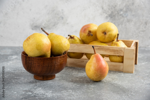 Bunch of fresh bio pears in wooden box and bowl