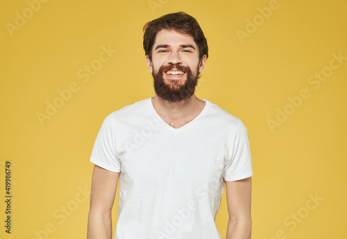 portrait of a man in a white t-shirt on a yellow background cropped view Copy Space