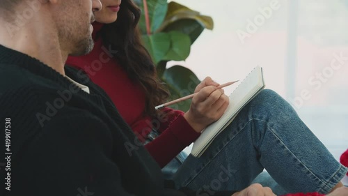 Man and woman couple in casual winter outfit sitting on bed in bedroom writing something on book with smile happy and romantic emotion