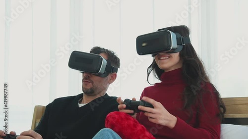 Man and woman couple in casual winter outfit playing a video game virtual reality vr together with happy and joyful emotion