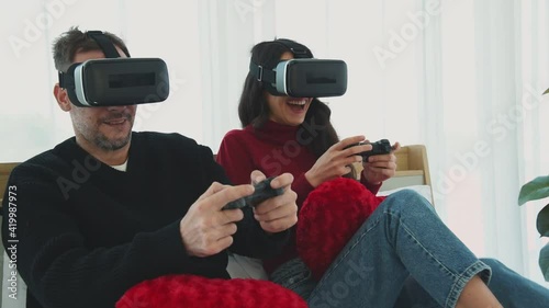 Man and woman couple in casual winter outfit playing a video game virtual reality vr together with happy and joyful emotion