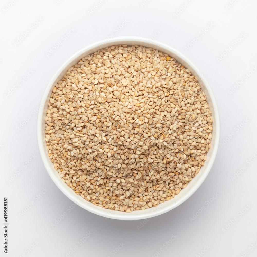 Organic White Sesame seeds(Sesamum indicum) or white Til with shell in white ceramic bowl Organic White Sesame seeds(Sesamum indicum) or white Til with shell in white ceramic bowl