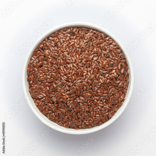 Organic Brown flaxseeds (Linum usitatissimum) or linseed in a white ceramic bowl , Top view
