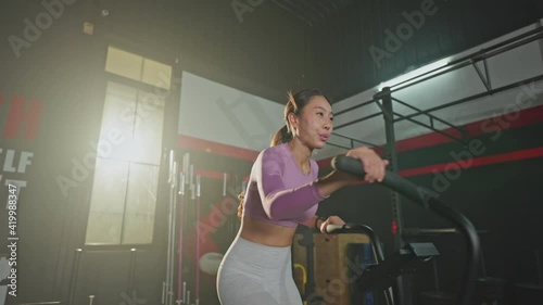 Asian young girl athlete spinning the stationary bicycle for exercise. photo