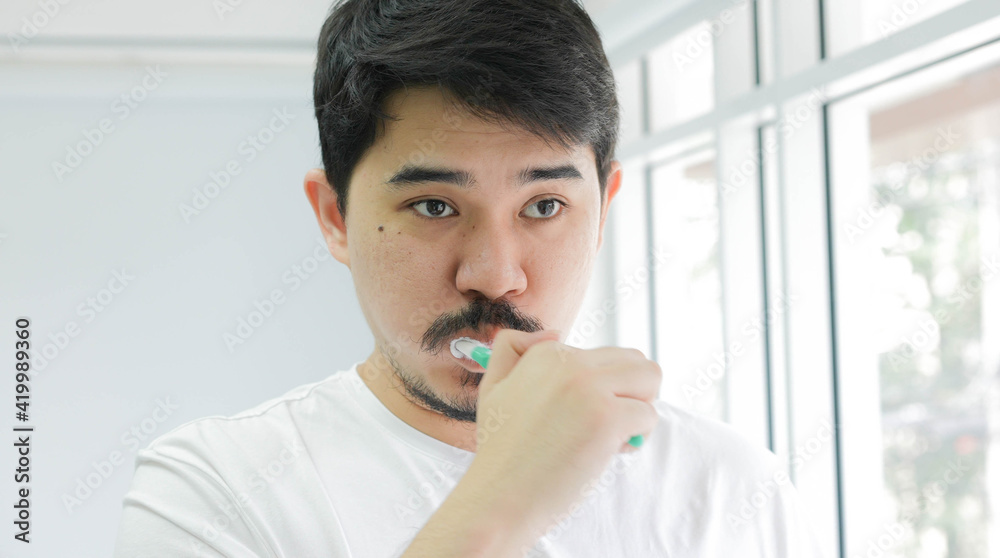 close up young Middle East man using toothbrush to brushing teeth at bathroom in the morning fro healthy and routine life concept close up young Middle East man using toothbrush to brushing teeth at bathroom in the morning fro healthy and routine life concept