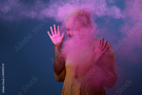 Fototapeta Naklejka Na Ścianę i Meble -  Woman plays with Holi festival colours.Concept for Indian festival Holi