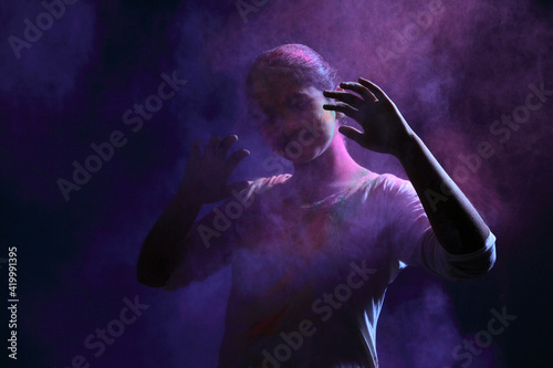 Silhouette of a girl plays with Holi festival colours.Concept for Indian festival Holi