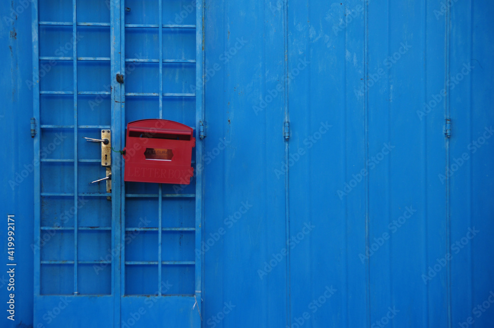 Red old letter box on blue wooden wall Red old letter box on blue wooden wall
