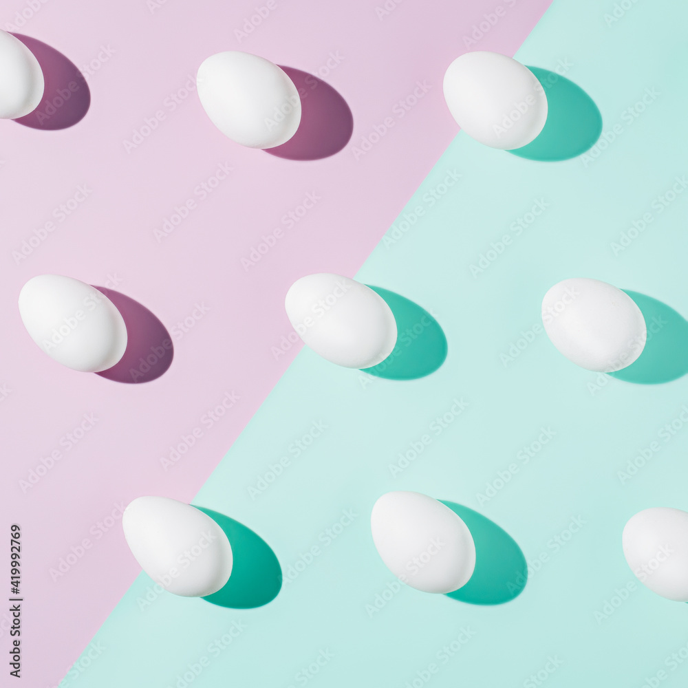Abstract Easter layout with eggs and trend summer shadows on two tone pastel violet and green background. Minimal spring holiday concept. Flat lay.