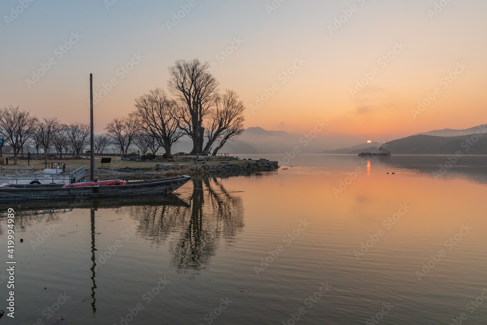 Sunrise over a misty riverside