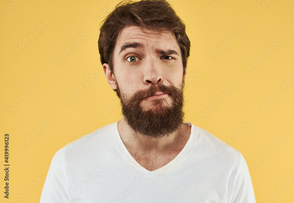 Close-up portrait of a happy man in a white t-shirt on a yellow background Close-up portrait of a happy man in a white t-shirt on a yellow background