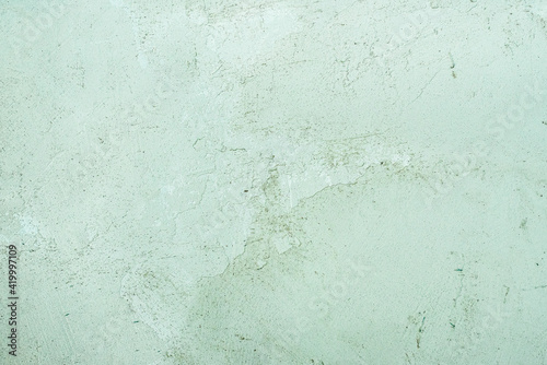 celadon green concrete old wall. cement texture. scuffs and cracks photo