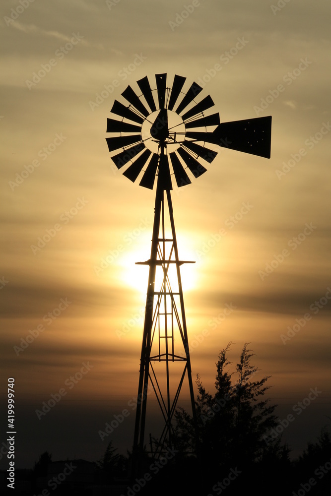 Windmill out in the country at Sunset with a colorful sky west of Nickerson Kansas USA . Windmill out in the country at Sunset with a colorful sky west of Nickerson Kansas USA .